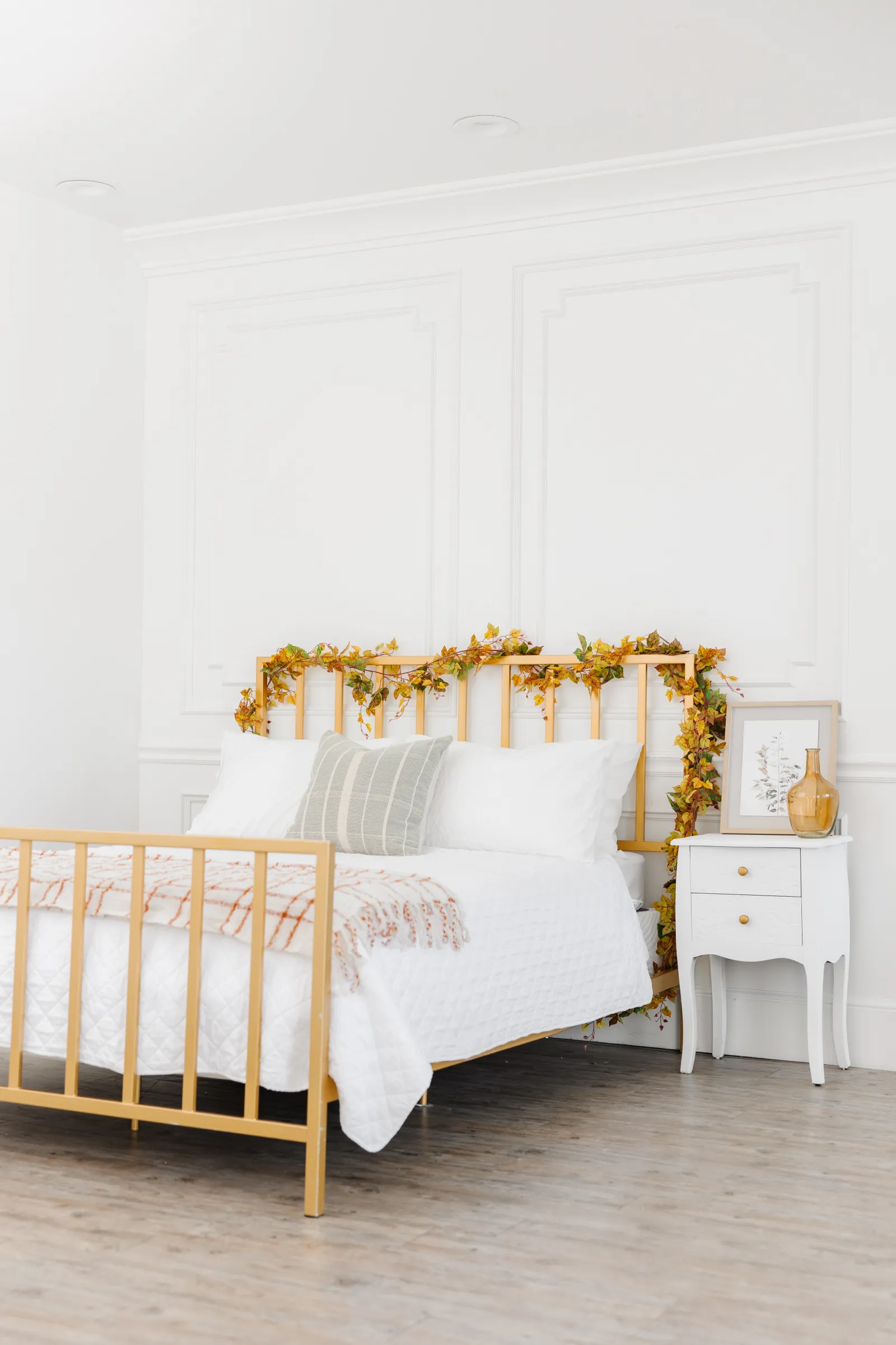 White bedding queen sized bed in a Gold bed frame