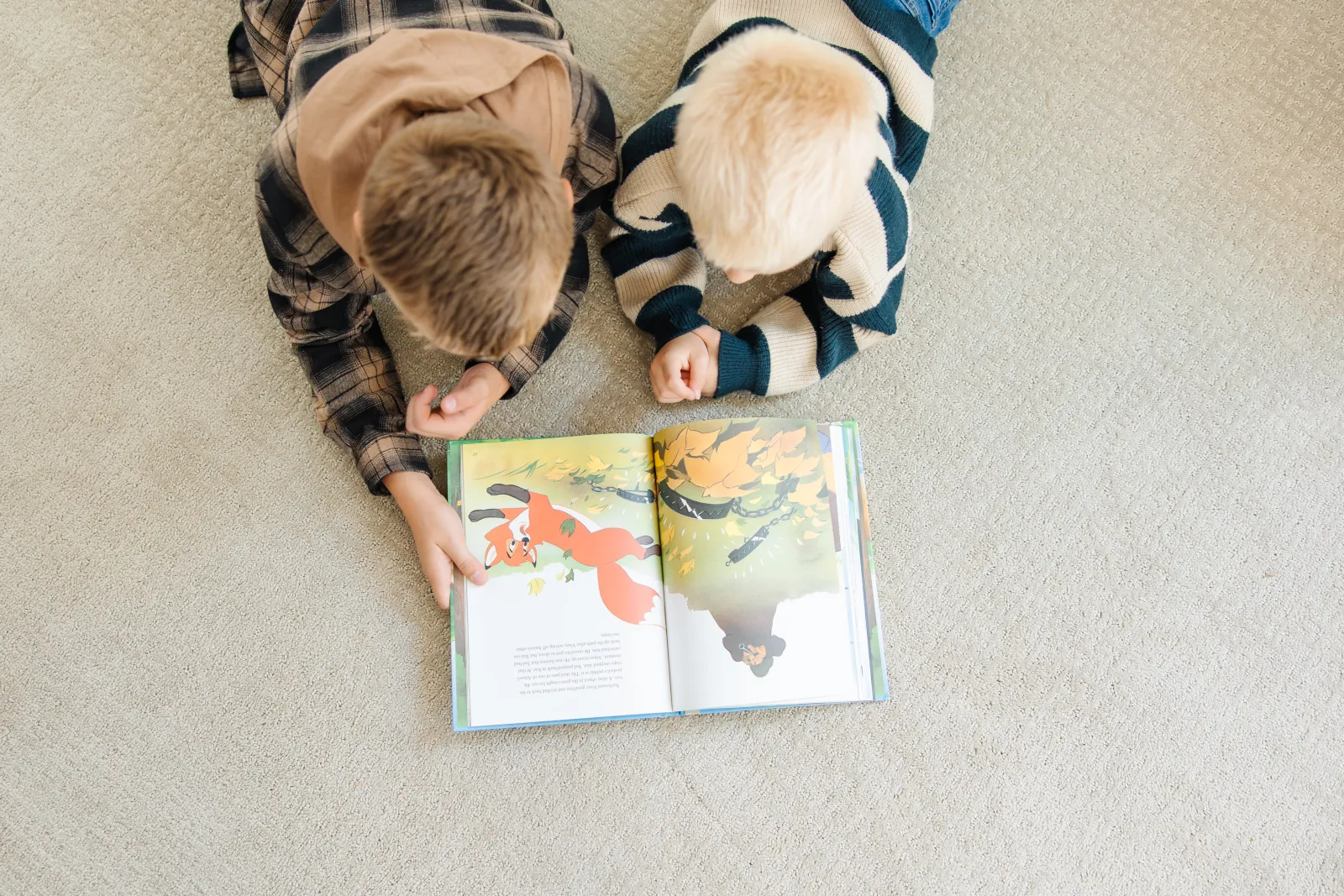 2 kids on cream carpet reading books