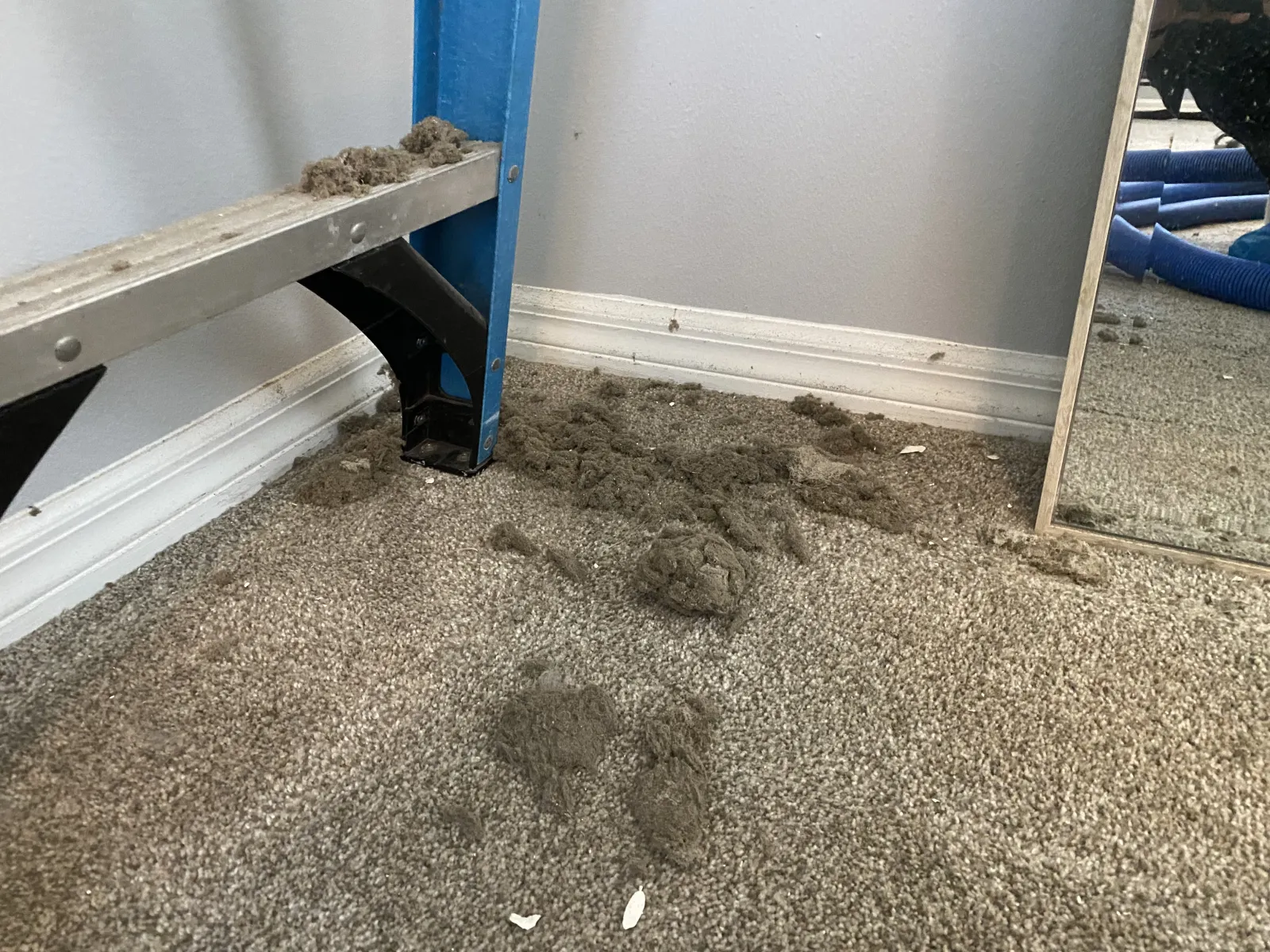 piles of dust bunnies on the floor after an air register was cleaned out from Zerorez professional air duct cleaning services