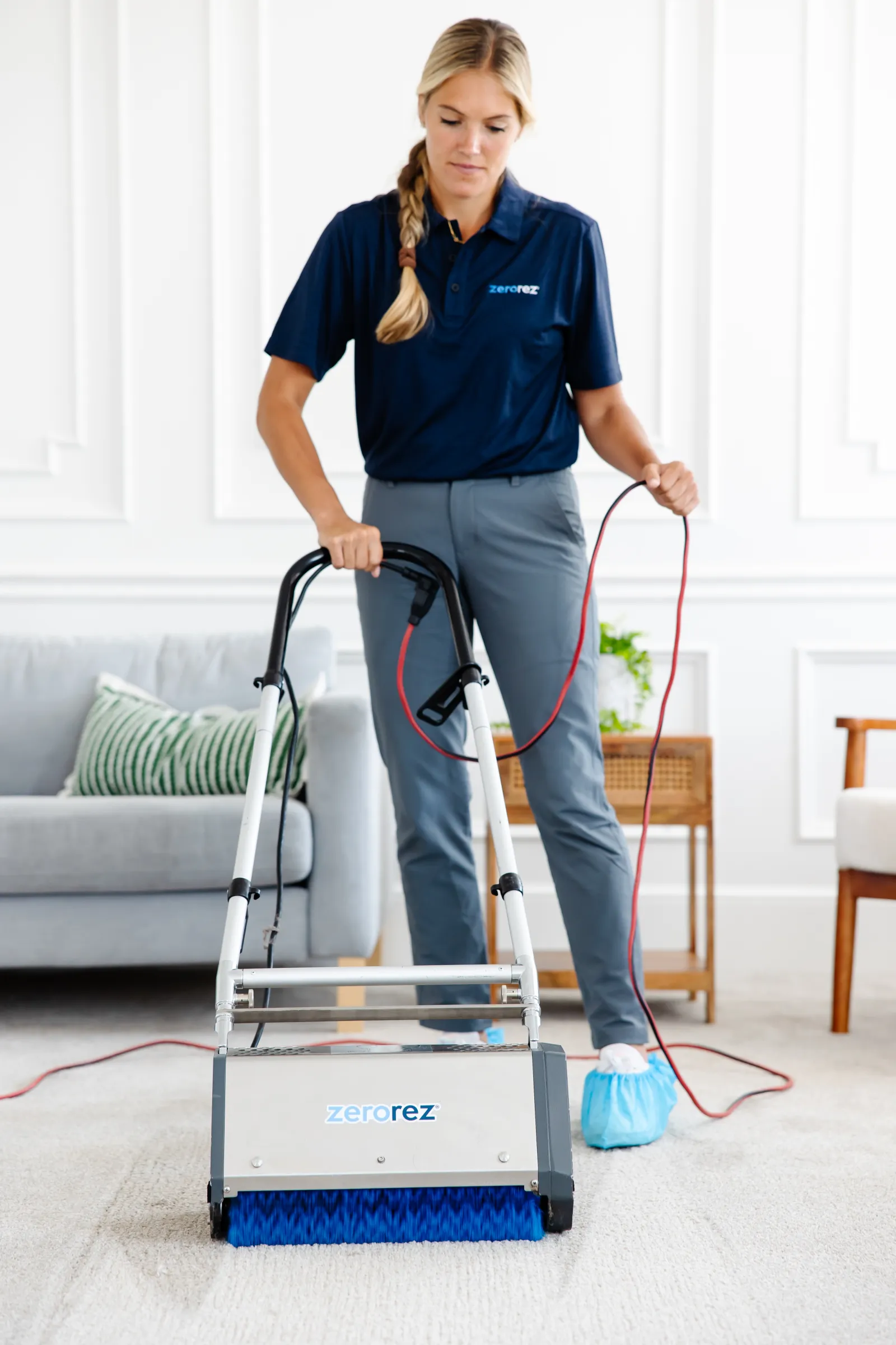 female Zerorez technician using a Zr™ Lifter to work in a pretreating carpet spray before cleaning the living room