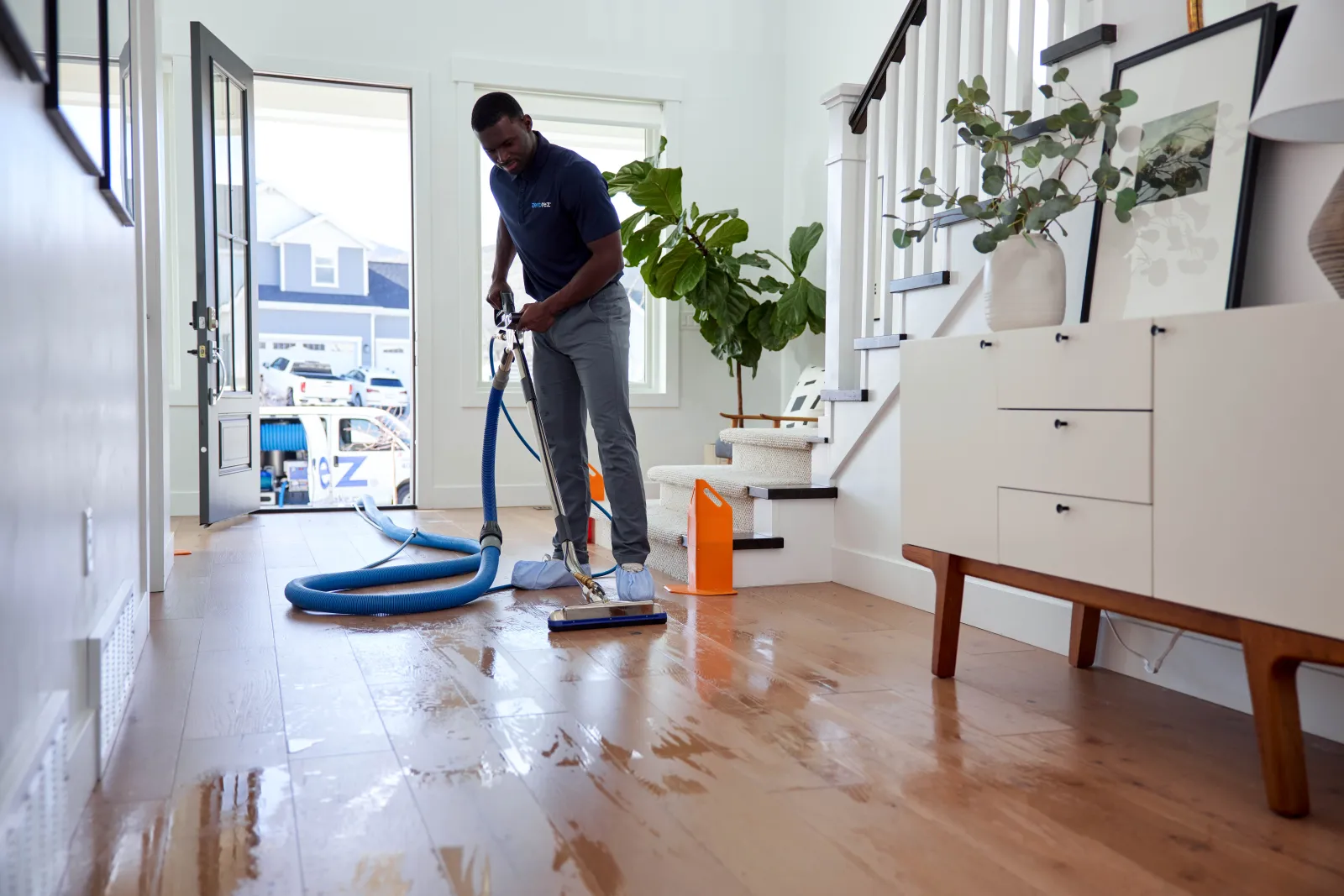 technician cleaning wood floors in a home