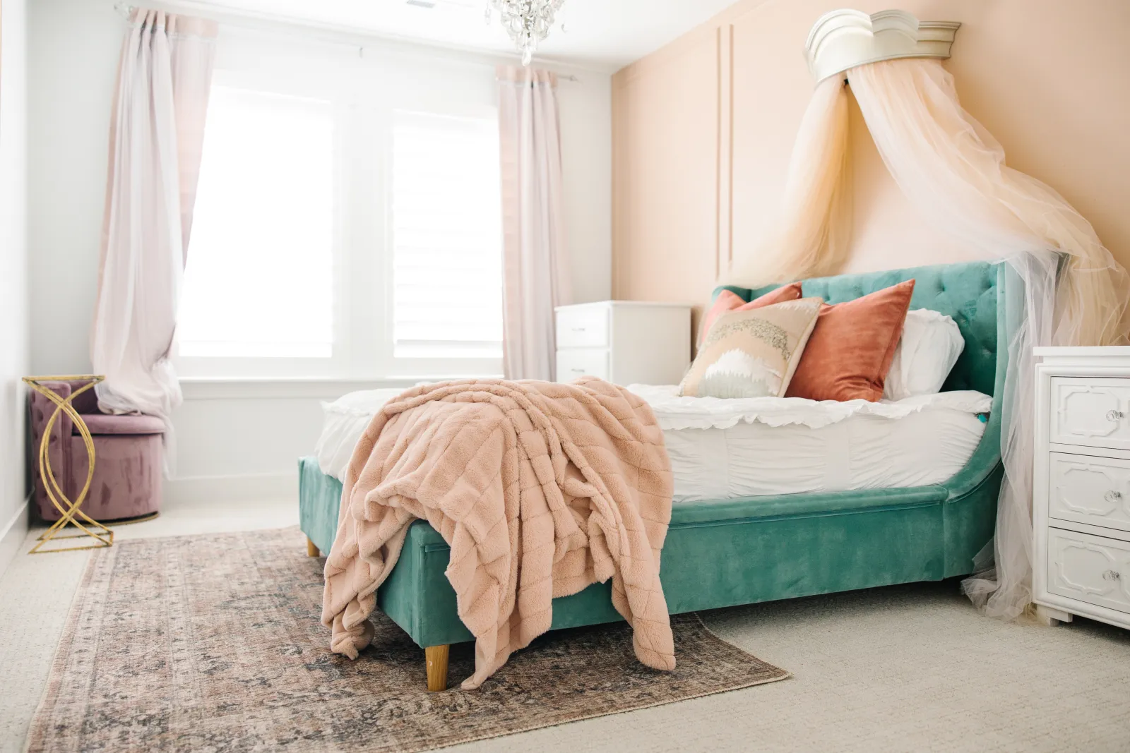 an area rug on top of a carpet underneath the feet of a heavy bed in a girls bedroom to help protect carpet from furniture feet