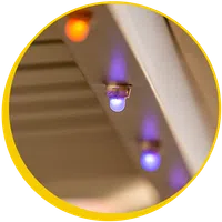 Close-up of blue and orange LED lights mounted on a beige surface with soft background blur.