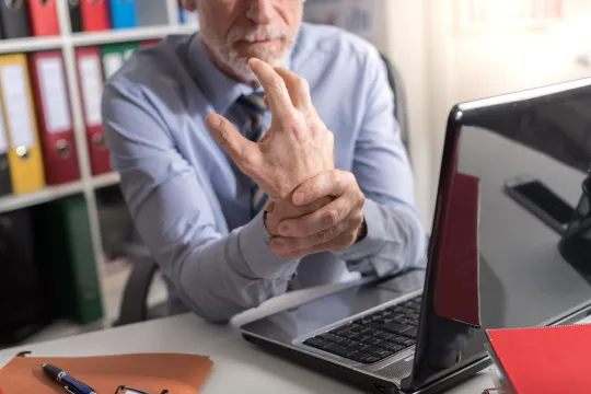 a man sitting at a desk with his hands on his face