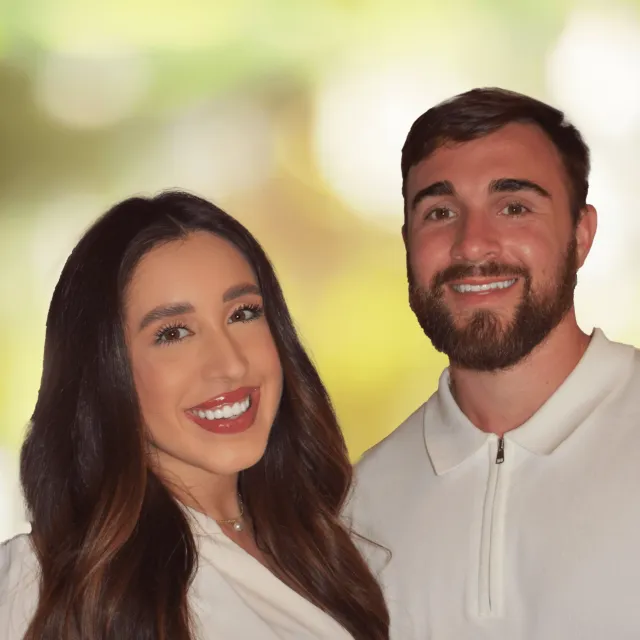 Smiling young man and woman posing together with soft-focus green-yellow background.