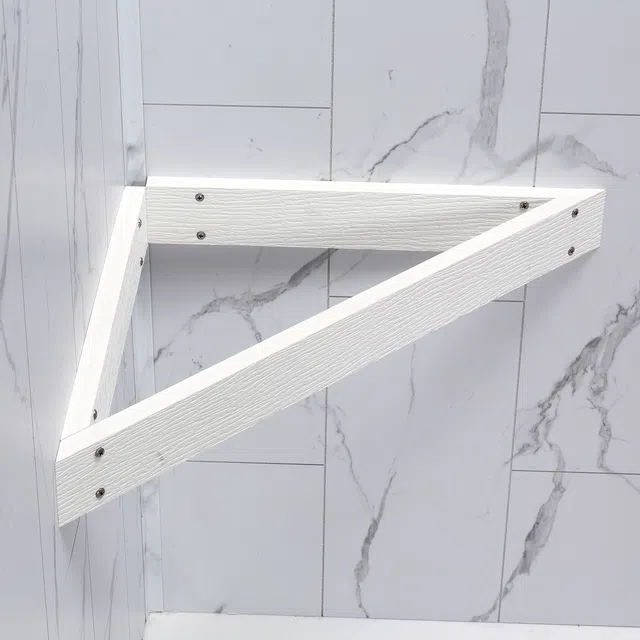White wooden triangular bench brackets mounted on a carrara marble-tiled wall and visible screws.