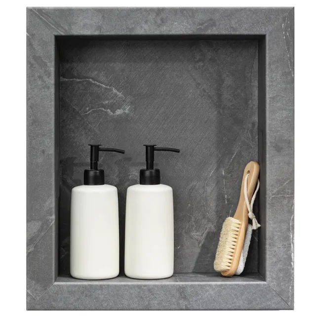 Two white pump bottles and a wooden bath brush with rope hanging, placed in gray stone shower niche.