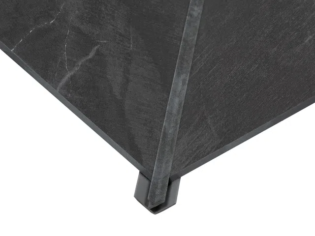 Close-up of umbrella corner with black fabric and metal frame visible on white background