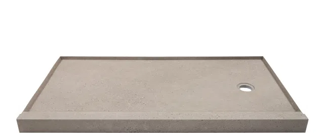 Rectangular beige stone shower base with raised edges and a circular drain hole on the right side.