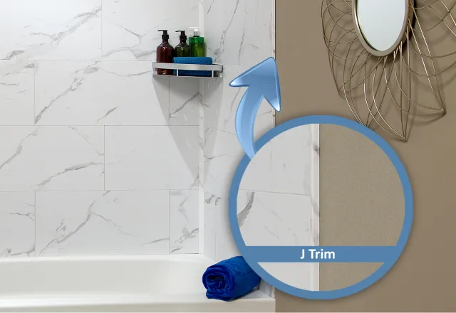 Close-up of bathroom corner with white marble tiles, J trim detail, blue towel, and decorative mirror.