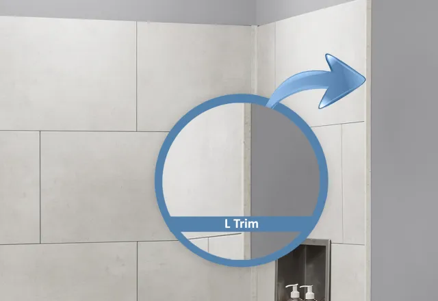 Close-up of tiled corner wall with L trim highlighting tile edge in a bathroom shower area.