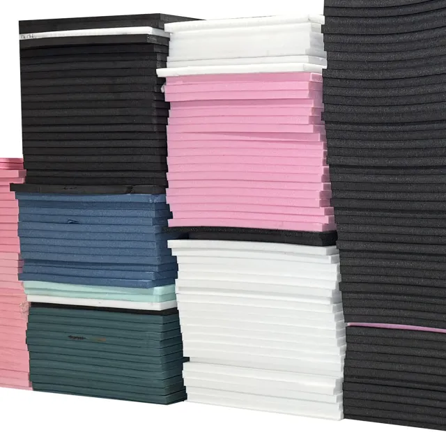 Stacked foam sheets in various colors including black, white, pink, blue, and green, arranged neatly.