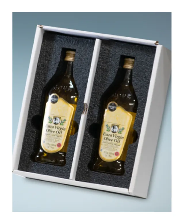 Two bottles of extra virgin olive oil in a white gift box with black foam inserts.