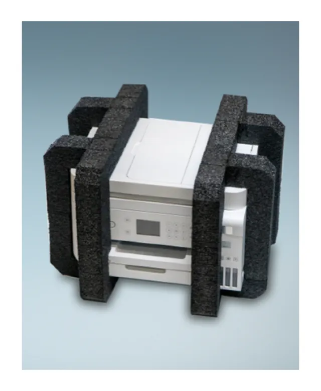 White office printer secured with black foam packaging material on a light background