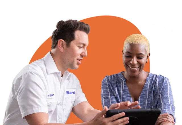 A technician shows a tablet to a smiling woman, highlighting collaboration and technology in service.