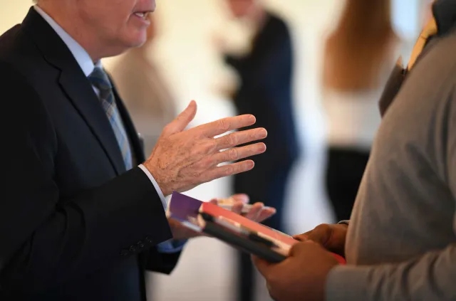 a man in a suit and tie holding a tablet