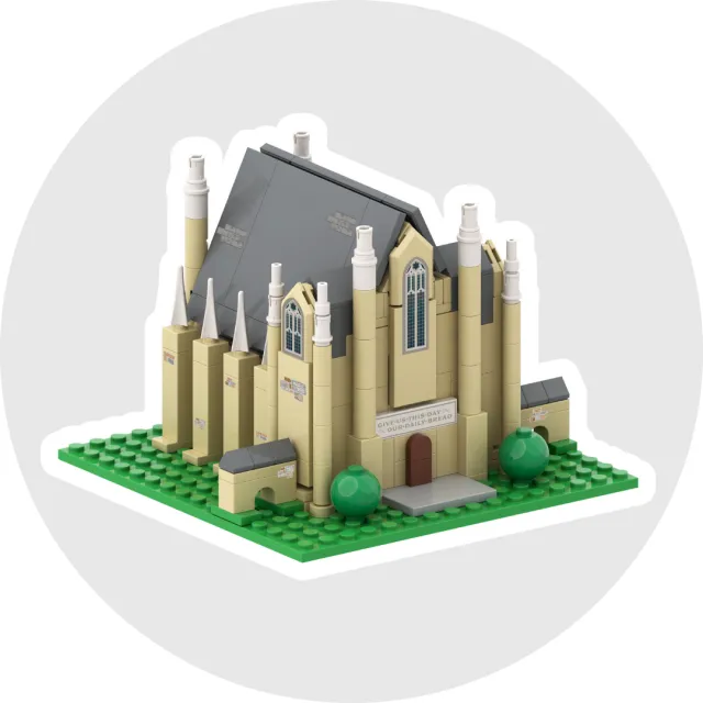 Detailed LEGO model of a Gothic-style church with tall spires and stained glass windows on a green baseplate.
