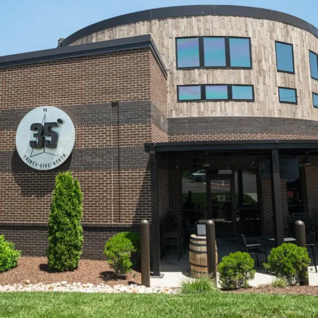 Modern brick building with a round wooden upper section and a 35° Thirty-Five North sign by the entrance.