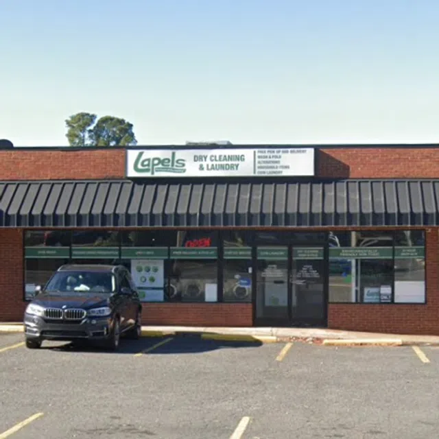 Lapels Dry Cleaning & Laundry storefront with car parked outside and clear signage under blue sky
