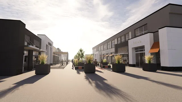 Modern outdoor shopping area with retail stores, planters, and people walking under a bright sky.
