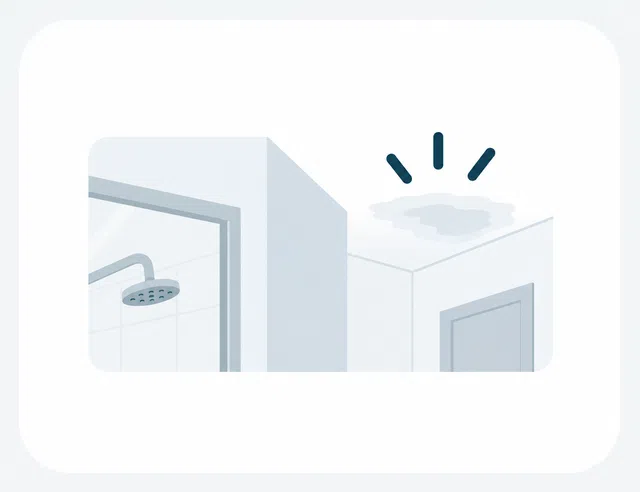 Bathroom ceiling with water leak causing a dark stain above the door and shower area.