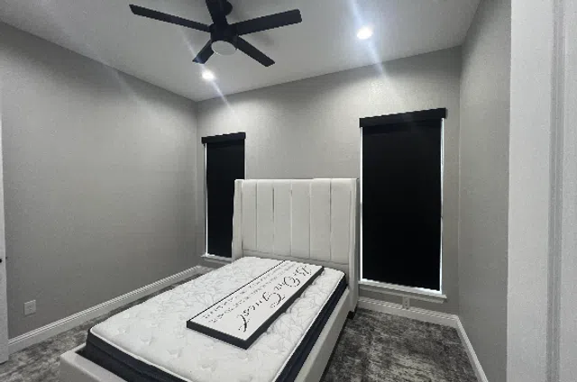Room darkening roller shades in a bedroom