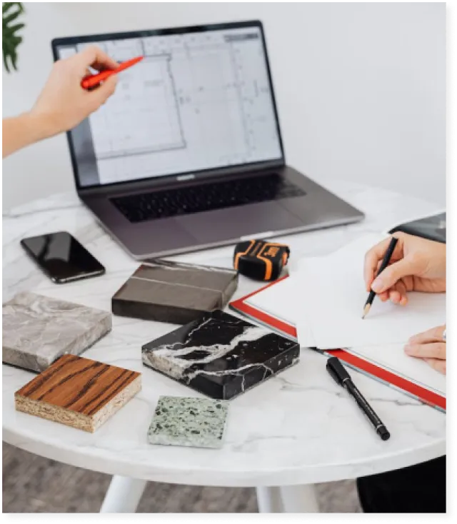 a laptop with a house plan and stone samples on a table