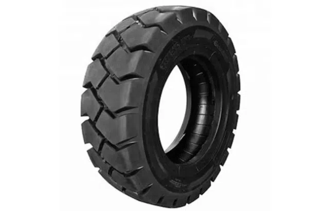 Heavy-duty black rubber tire with deep treads for off-road or industrial vehicles on white background