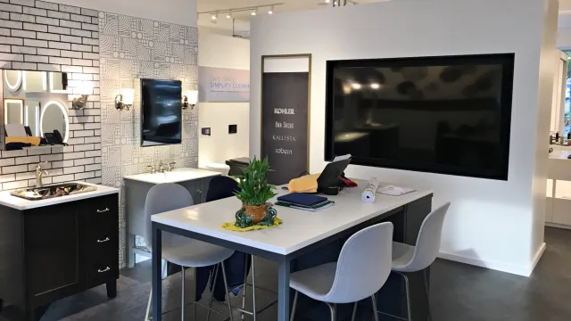 Modern kitchen display featuring fixtures, furnishings, and a large wall-mounted screen.