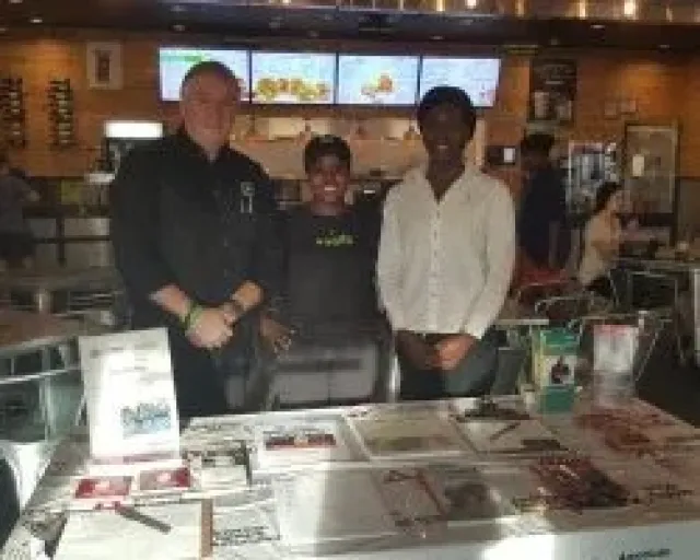 a group of men standing next to a table with a model of a city