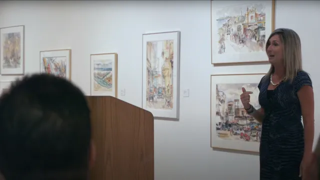a person standing in front of a wall with pictures on it