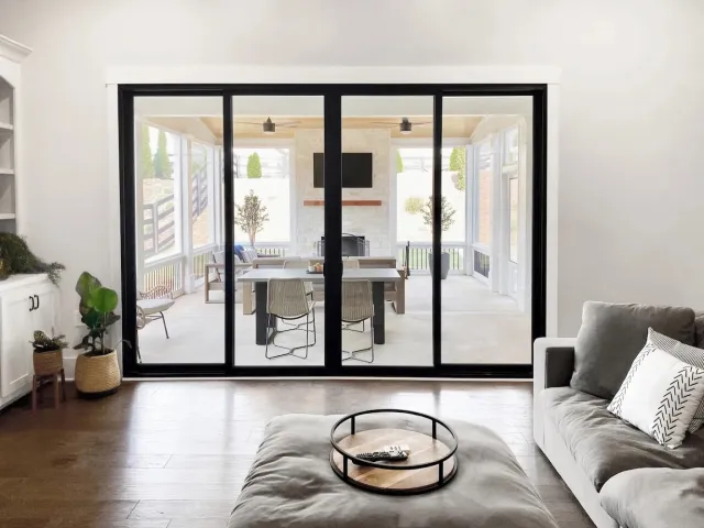 Black sliding patio doors installed between living room and screened porch