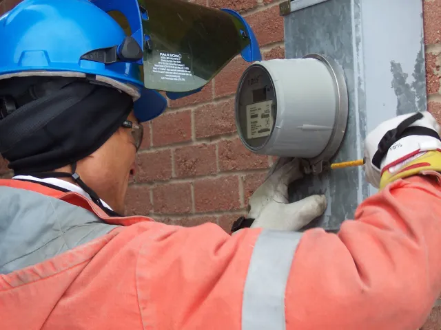 a man wearing a helmet and gloves holding a metal cylinder