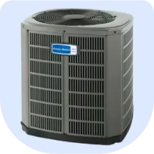 Gray outdoor air conditioning unit with metal grille and top fan against light background