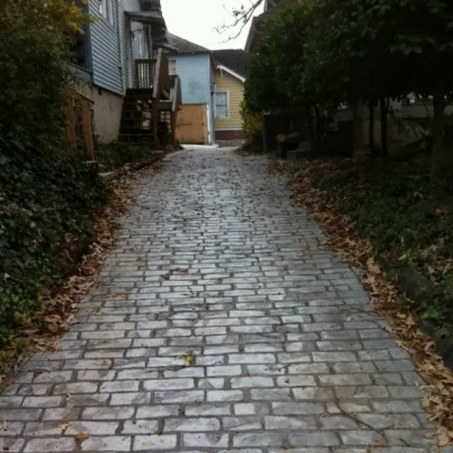 a cobblestone road with houses on either side of it