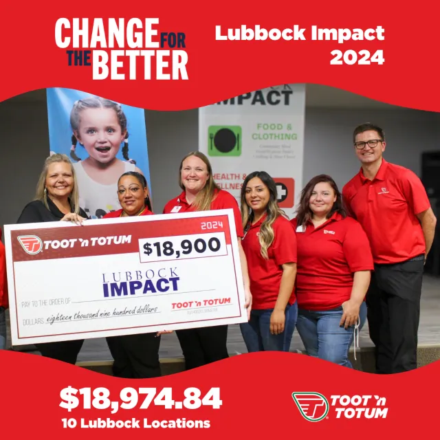 Group of six people holding a large $18,900 Lubbock Impact check from Toot 'n Totum in 2024 charity event.