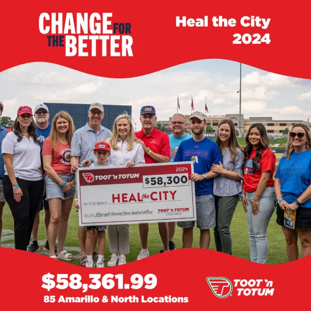 Group of people holding a large $58,300 check for Heal the City 2024 at an outdoor event in Amarillo.