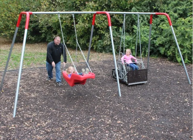 a person and two children on a swing set