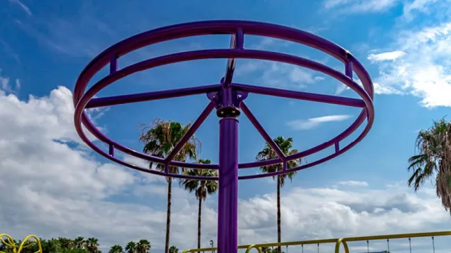 a roller coaster with trees and blue sky