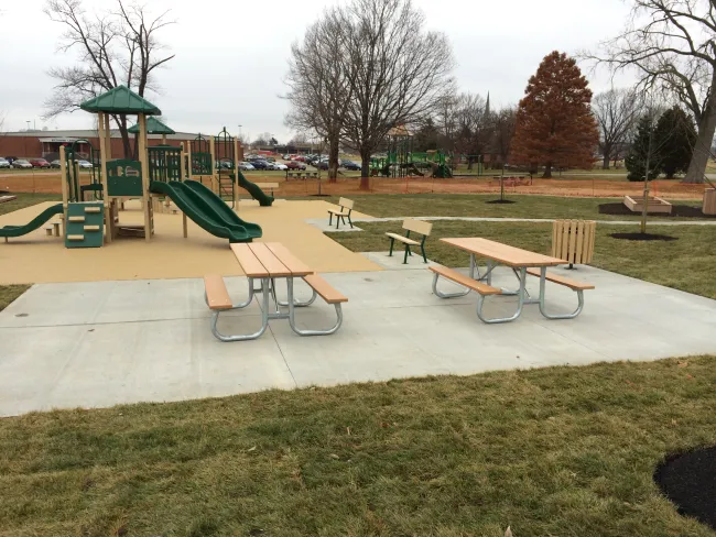 a playground with a slide and tables