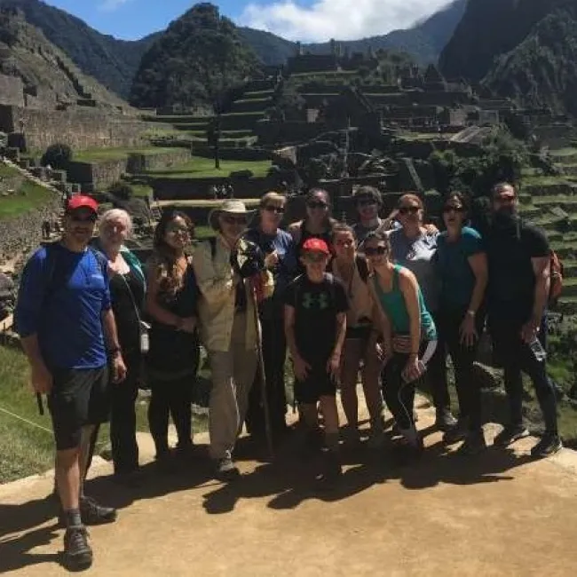 a group of people posing for a photo in front of a mountain