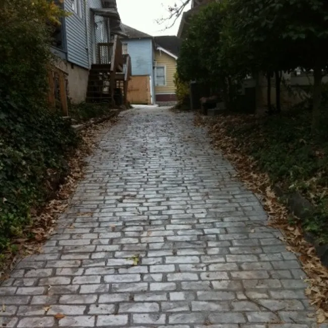 a cobblestone road with houses on either side of it