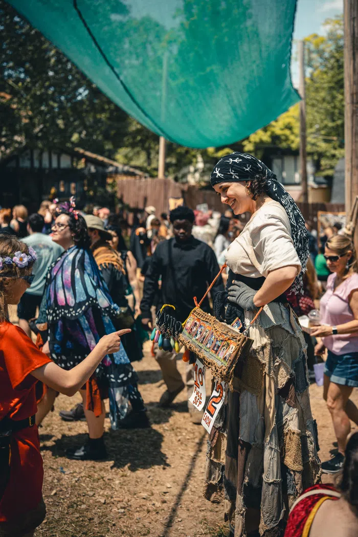 A Festival artisan helps a guest at a craft shop