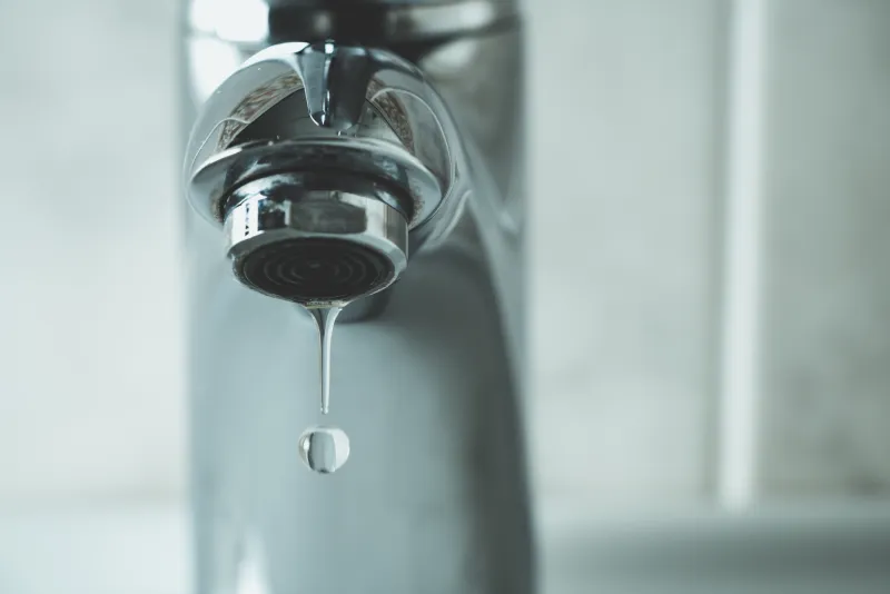 a drop of water coming out of a faucet