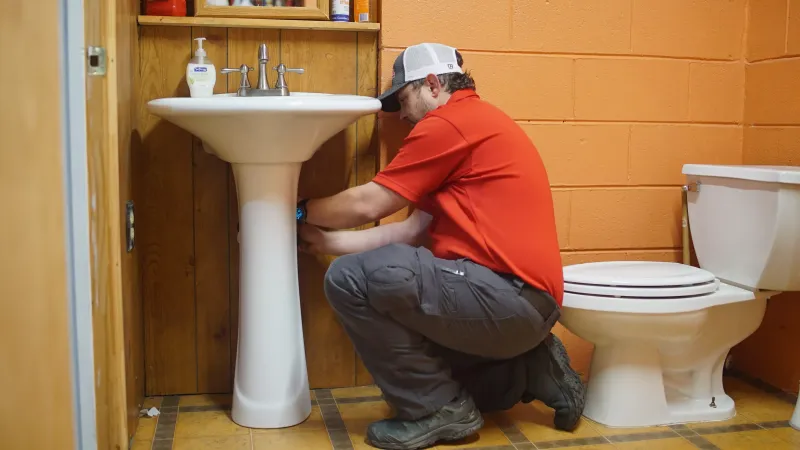 a man squatting in front of a toilet