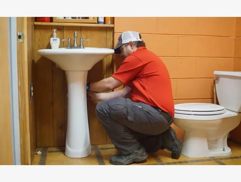 a man squatting in front of a toilet