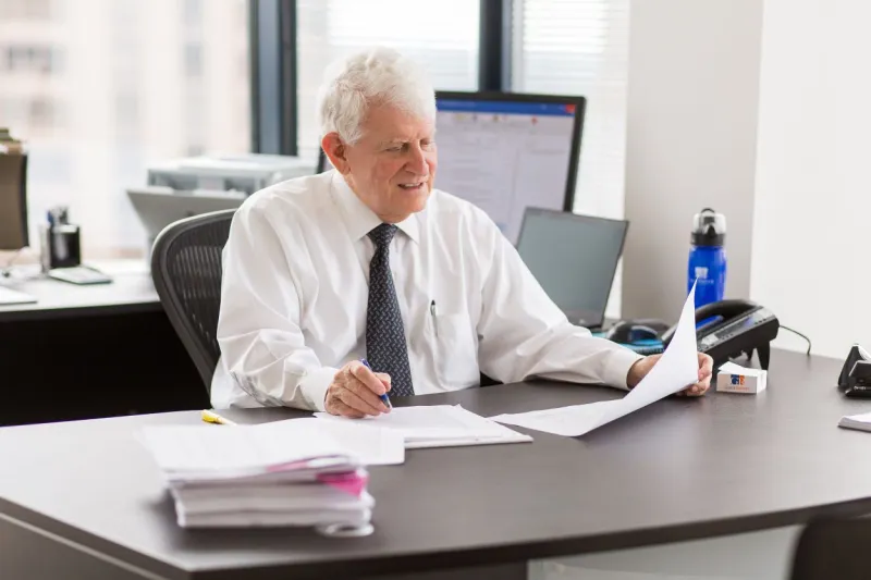 a man sitting at a desk with a laptop on a table