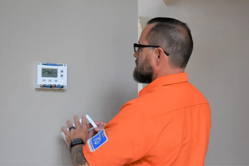 a man installing a thermostat