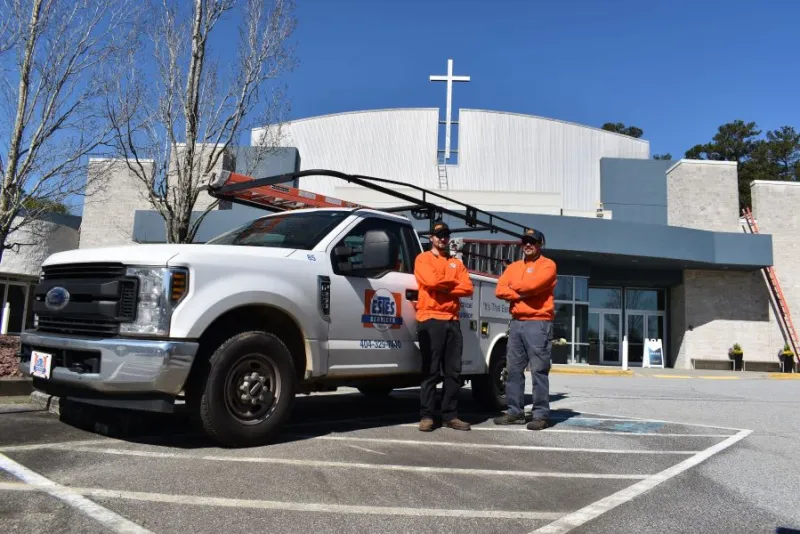 technicians outside a church