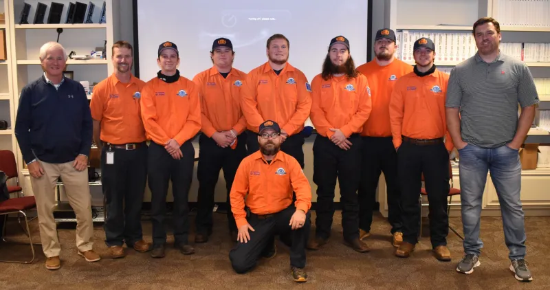 a group of people wearing orange shirts